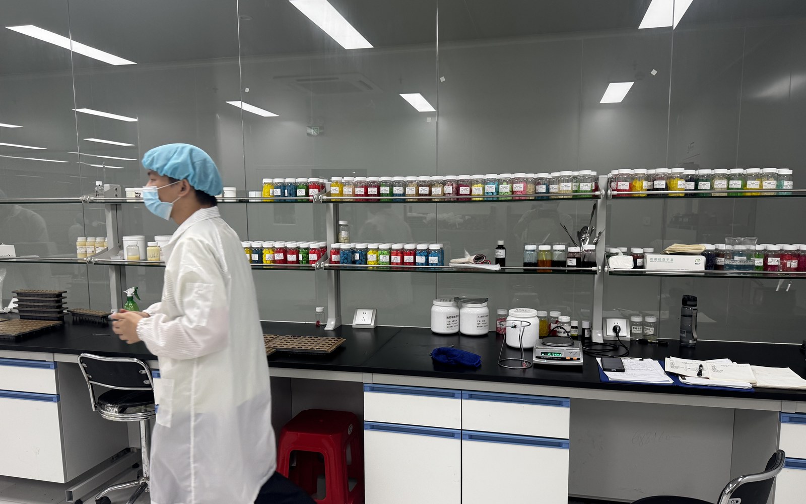 Staff member beside a lab bench and colorful raw ingredient jars in NuCoreBio R&D lab